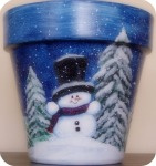 Terra Cotta planters Snowman in wintery scene with pine trees and snow

